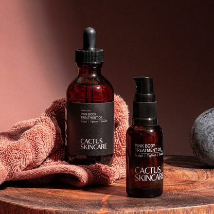 Cactus Skincare Pink Body Treatment Oil 100ml dropper and travel pump bottles on a timber slab